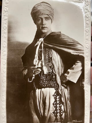 Item #22-4409 Real photo postcard "The Late Rudolph Valentino" showing a standing Valentino in a...